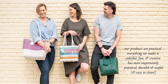 Three smiling people in front of sand colored brick wall. Each are holding a cesta tote made from recycled plastic cord in a variety of colors. text that says 'our products are practical ~ everything we make is colorful, fun & creative but most importantly practical, durable & useful (& easy to clean!'